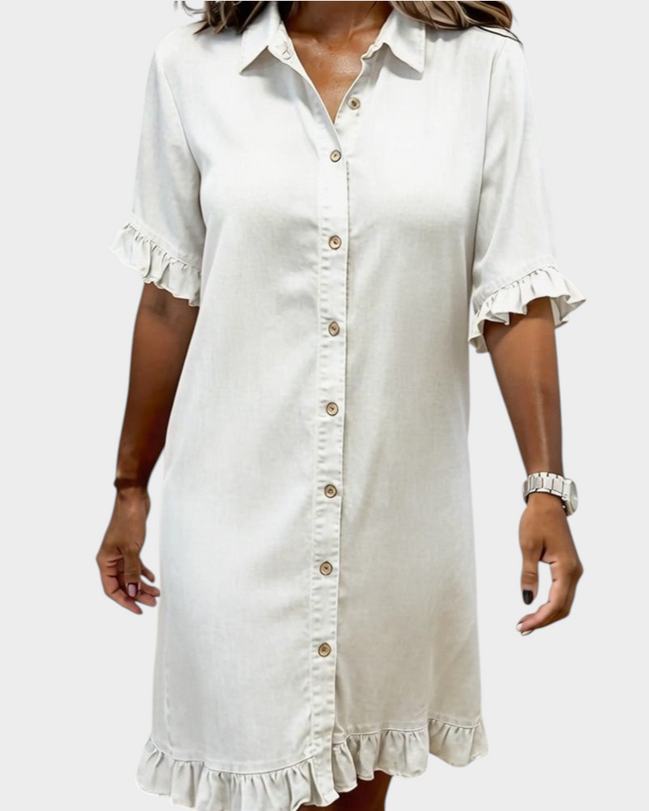 Aurore Paris beige cotton denim shirt dress with a button-down front, collar, and ruffled sleeves and hem.