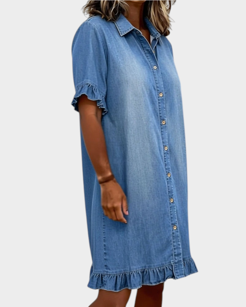 Aurore Paris blue denim shirt dress with a collar, button front, and ruffled sleeves and hem, worn by a woman.