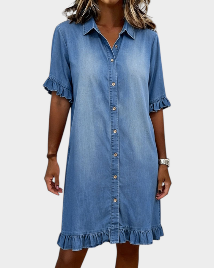Aurore Paris blue denim shirt dress with a button-down front, collar, and ruffled sleeves and hem.
