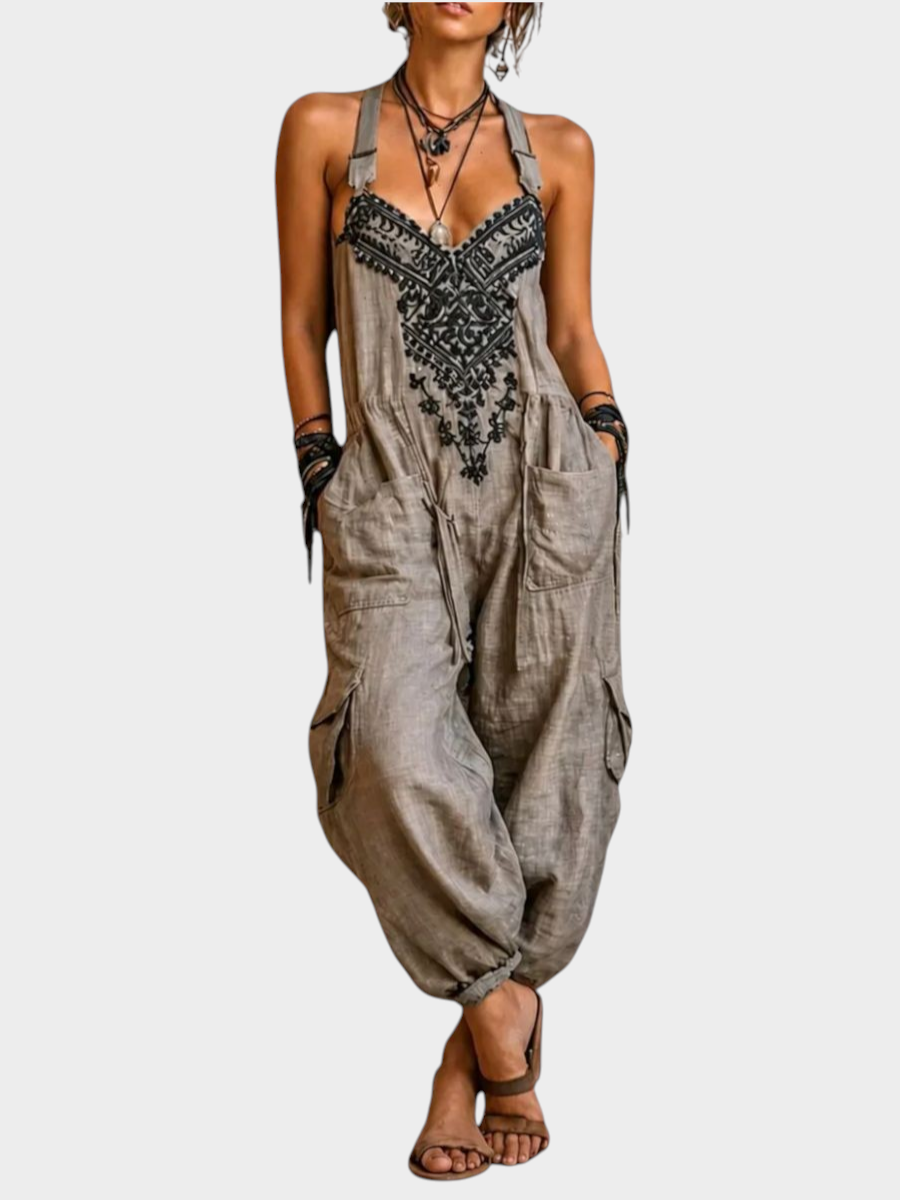 Aurore Paris bohemian jumpsuit in beige with black artisan embroidery, adjustable straps, and side cargo pockets.