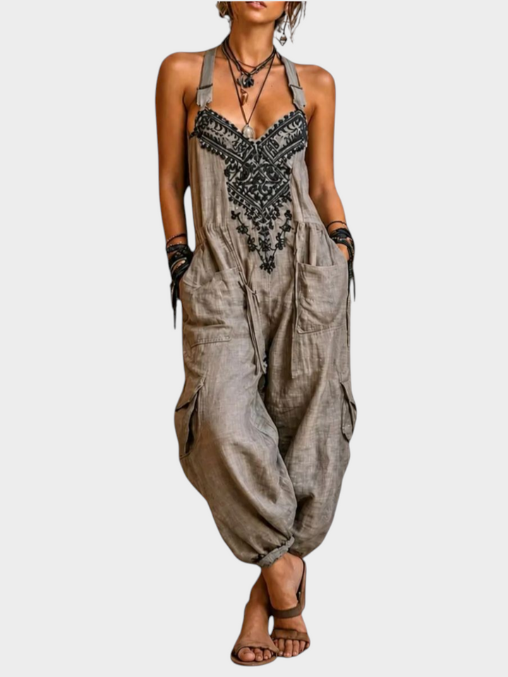 Aurore Paris bohemian jumpsuit in beige with black artisan embroidery, adjustable straps, and side cargo pockets.
