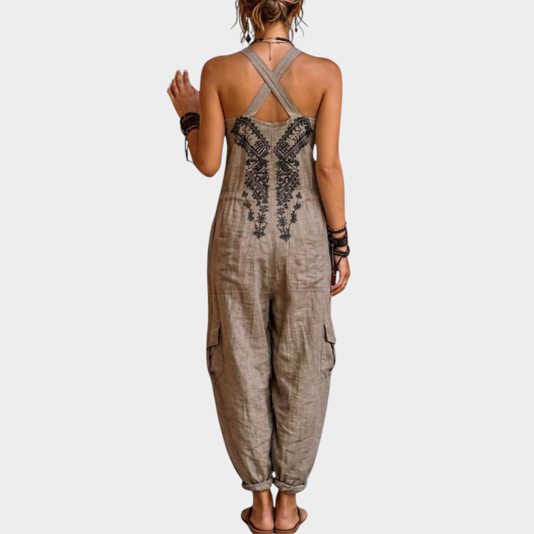 Aurore Paris Estelle bohemian jumpsuit in beige with black artisanal embroidery, cross-back straps, and cargo pockets.